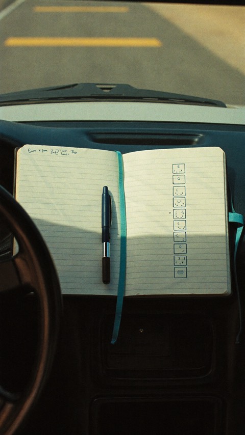 Video poster: a checklist notebook resting on a car dashboard.