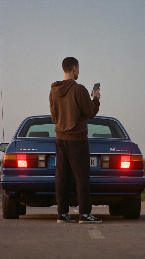 Video poster: a person photographs the rear bumper of their car.